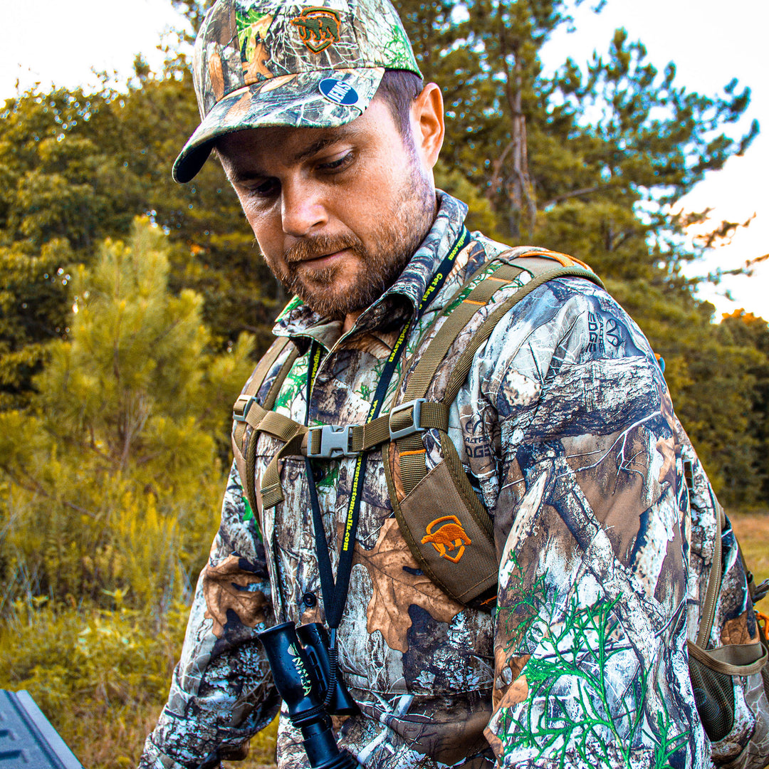 Man in Trek Shirt with a backpack and gear in a forest setting.